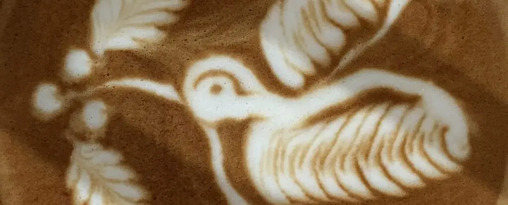 Nahaufnahme eines Latte Art Designs, das einen Vogel darstellt, auf einem Cappuccino